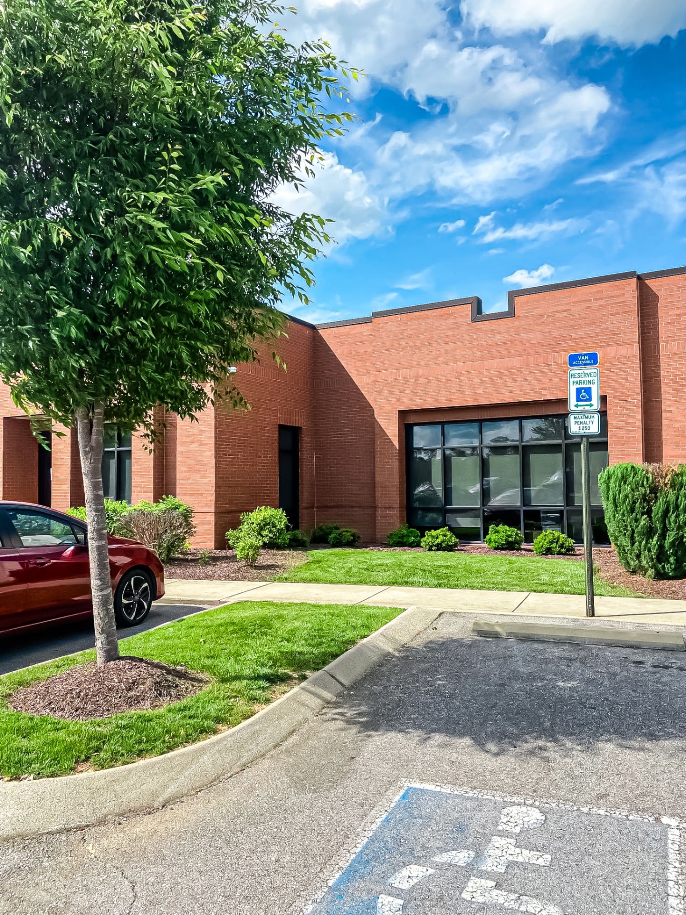 Professional commercial landscaping with manicured shrubs and lawn at Tennessee brick office building by Prestige Landscape