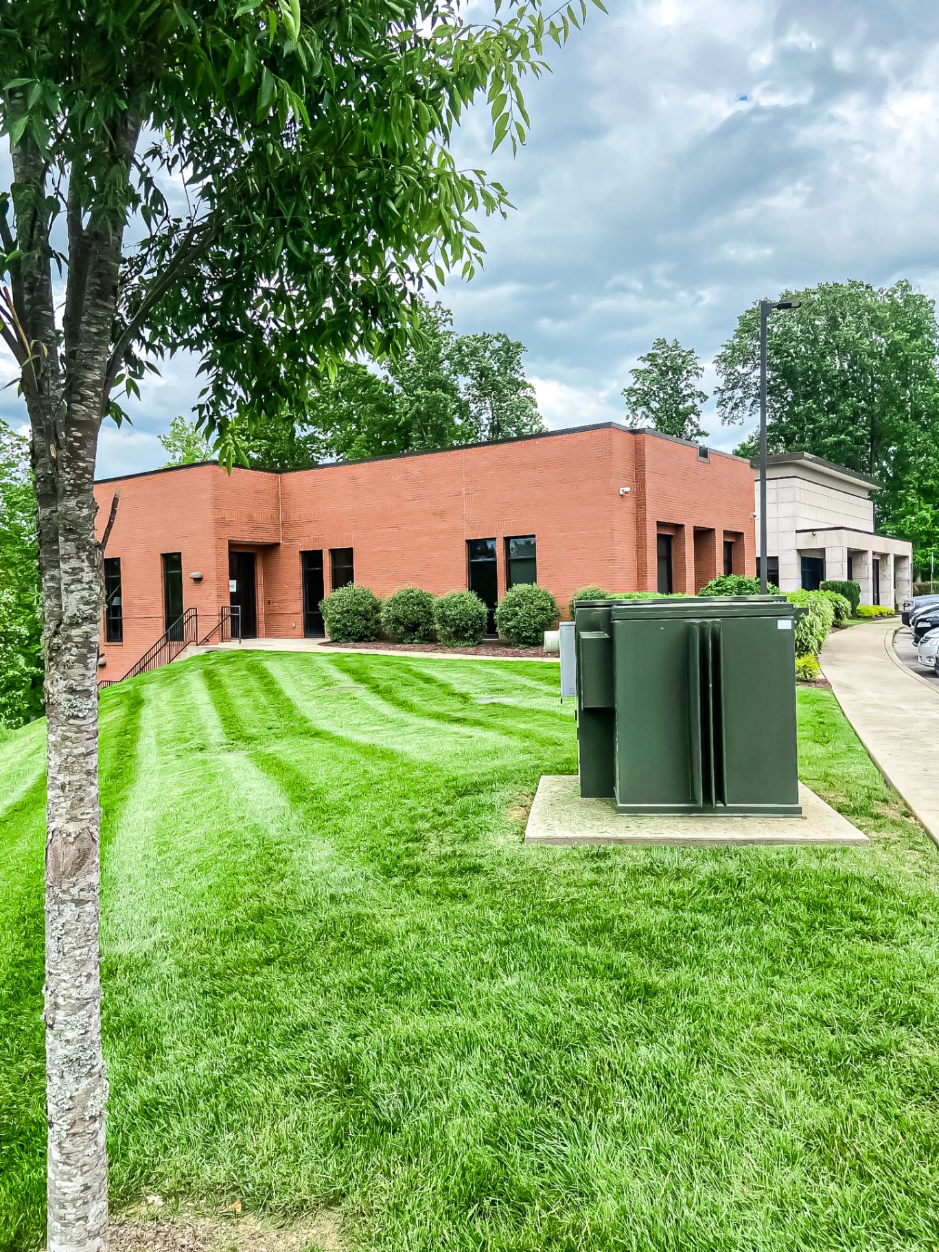 Commercial lawn mowing with professional stripe patterns at Tennessee office building by Prestige Landscape
