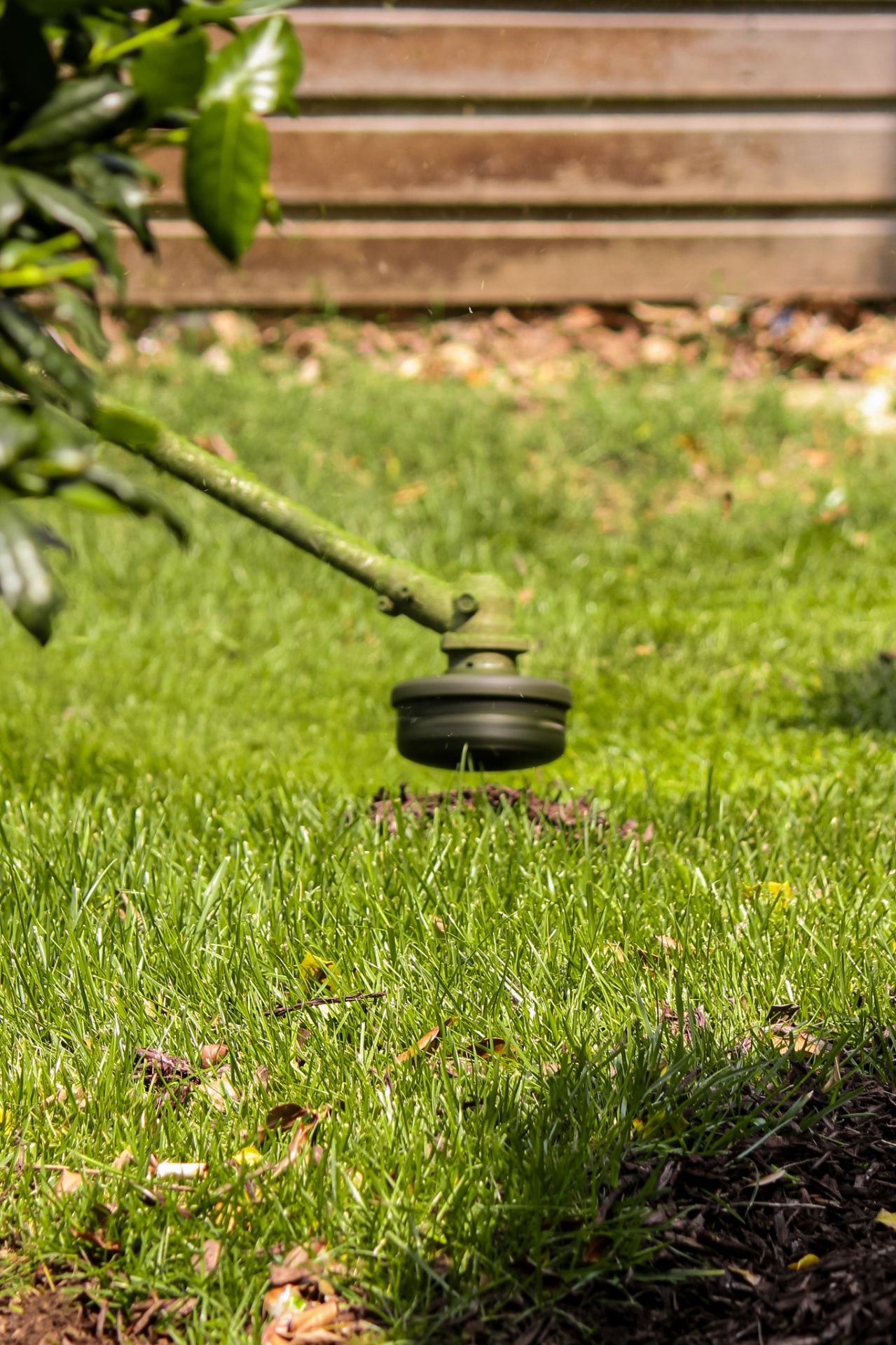Precision string trimming along mulch bed and fence line at maintained Tennessee property by Prestige Landscape