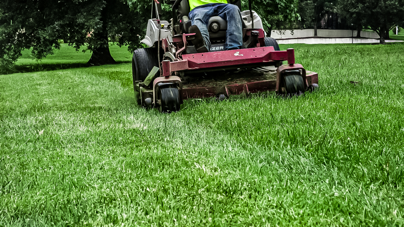 Professional lawn mowing with precise striping pattern on residential property in Tennessee