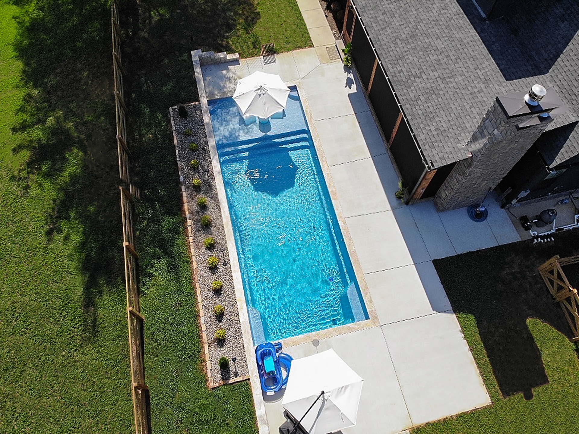 Aerial drone view of custom outdoor living space with concrete patio and landscape border in Tennessee