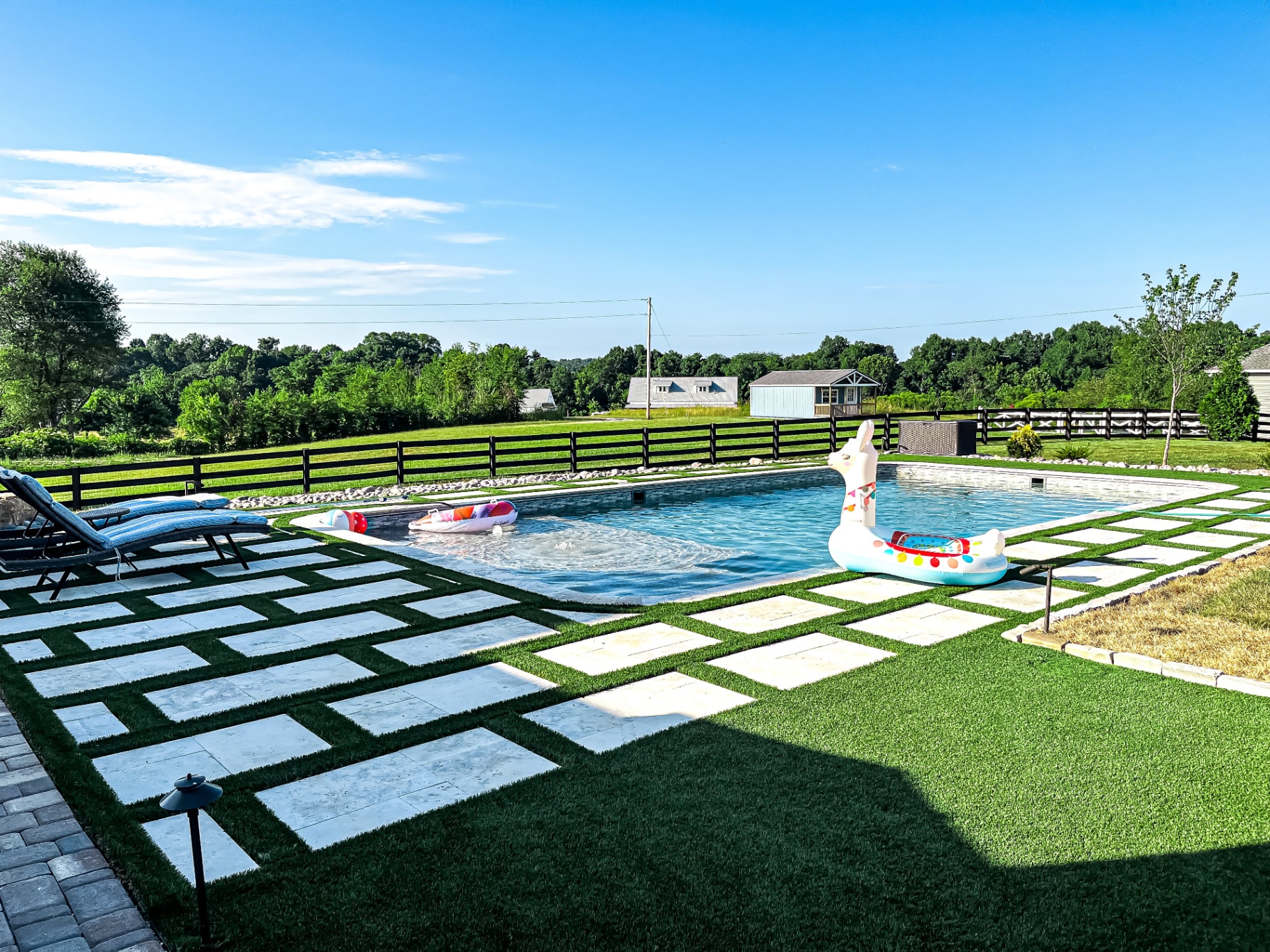 Custom outdoor space with synthetic turf and natural stone paver patio in Tennessee backyard by Prestige Landscape